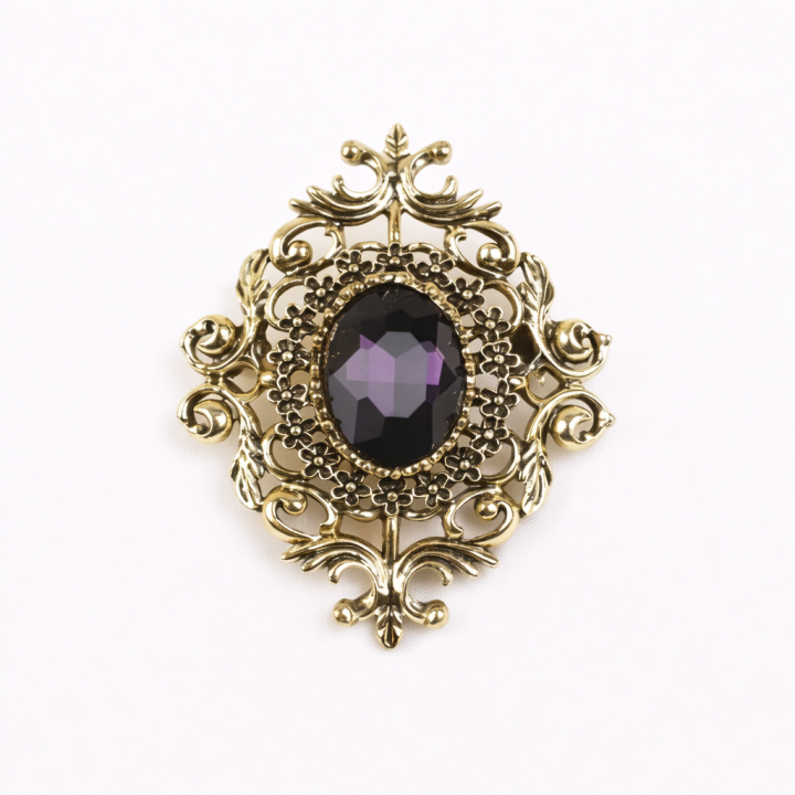 Broche doré avec fausse pierre violette