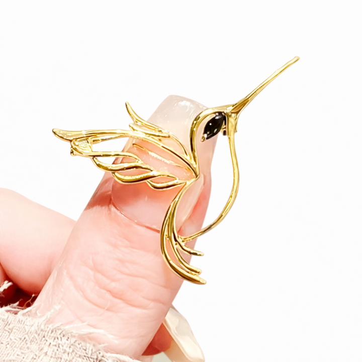 Broche élégante en forme d'oiseau ajouré avec plumes dorées et œil en pierre noire